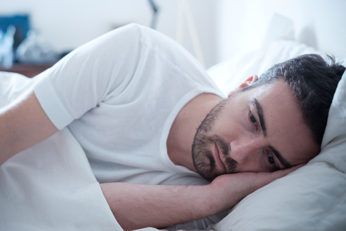 Homme au lit n'arrivant pas à dormir